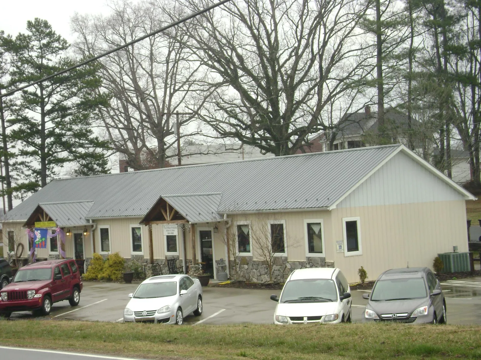 Gray metal roof with timber entry brackets on a small commercial building in Greenfield